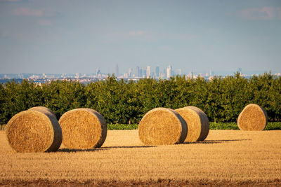 Hay bales on field against sky