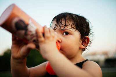 Close-up portrait of cute child drinking water