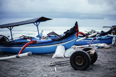 Boats moored on sea shore against sky