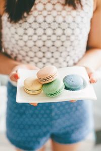 Midsection of woman holding macaroons