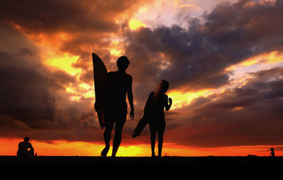 Silhouette people against sky during sunset