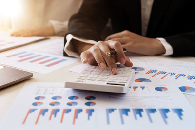 Midsection of businessman working on table