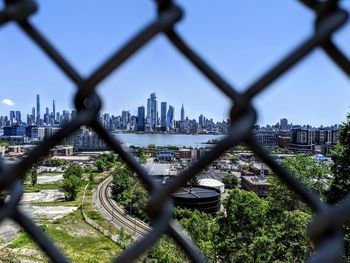 View of buildings seen through chainlink fence