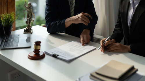 Midsection of lawyer working on table