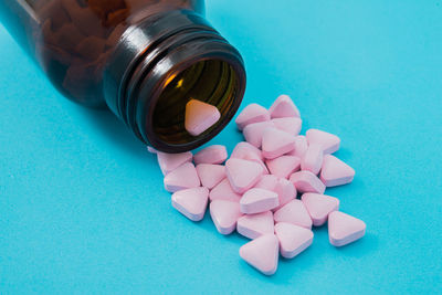 Close-up of pills and bottle against blue background