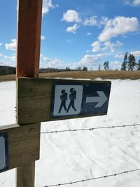 Information sign against cloudy sky