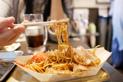 Midsection of woman eating spaghetti in restaurant