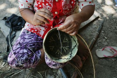 High angle view of woman weaving basket