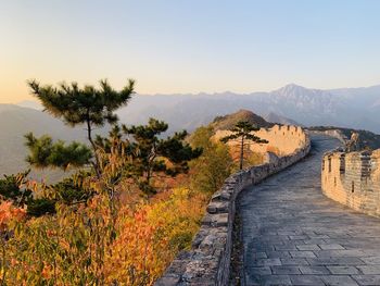 Footpath on the great wall amidst trees against sky