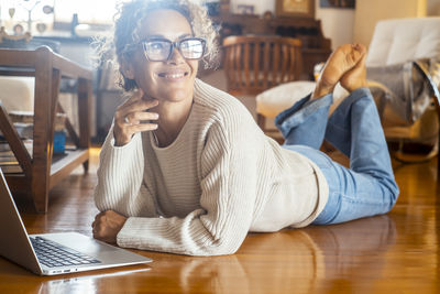 Portrait of woman using laptop at home