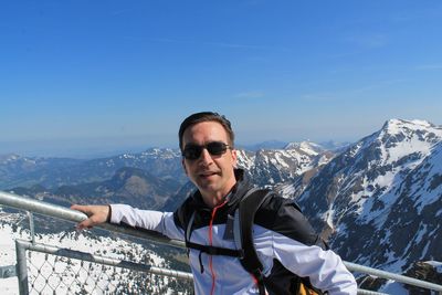 Close-up of man standing by railing against sky