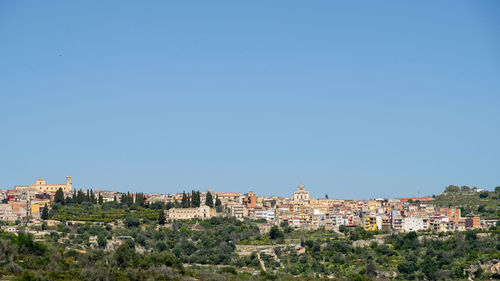 View of townscape against clear blue sky