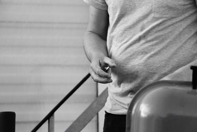 Low section of man standing on railing