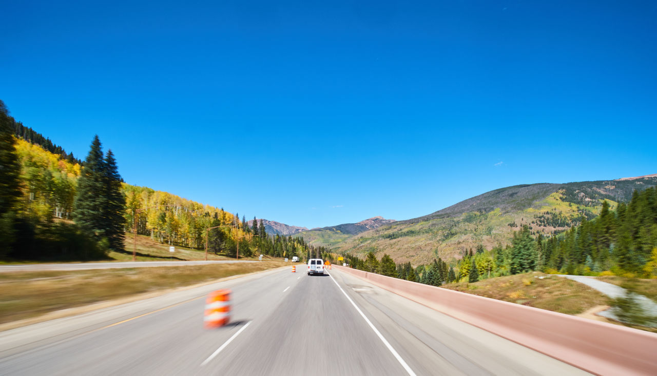 CAR ON ROAD AGAINST BLUE SKY