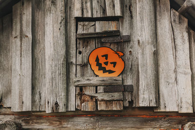 Halloween decor outdoors. paper pumpkin on wooden building of the bathhouse in village.