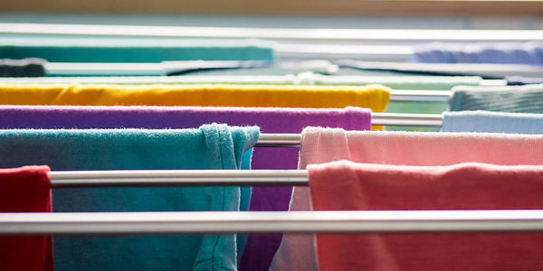 Laundry day rainbow color clothes hanging on washing line to dry indoors home