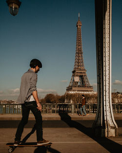 Full length of young man tower against sky in city