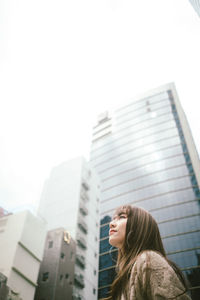 Low angle view of woman standing against buildings