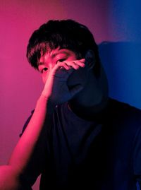 Portrait of young man standing against wall