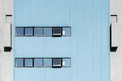 White building against blue sky seen through window