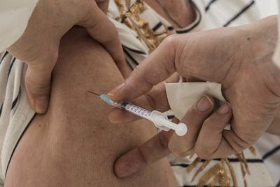 Midsection of doctor holding syringe