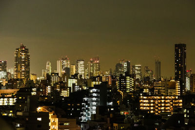 Illuminated cityscape against sky at night