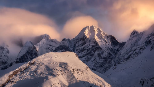 Scenic view of snow covered mountains against sky during sunset