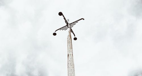 Low angle view of street light against cloudy sky