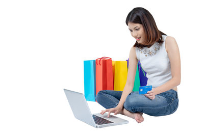 Young woman using phone against white background