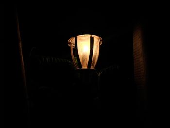 Low angle view of illuminated lamp in darkroom
