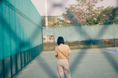 Rear view of man standing against wall