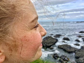 Close-up of girl with sea in background