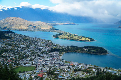 High angle view of city by sea against sky