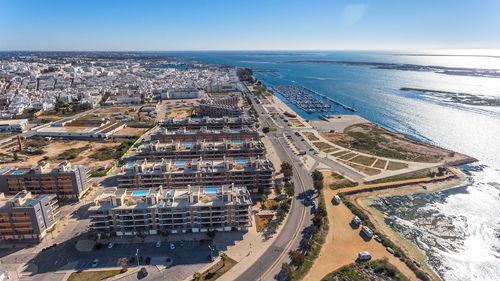 High angle view of city by sea against sky