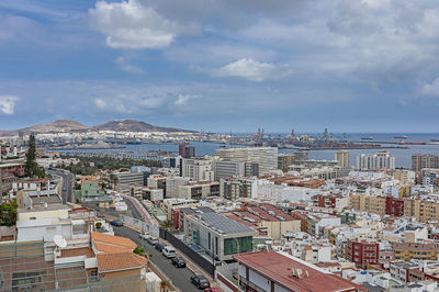 High angle view of buildings by sea against sky