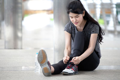Full length of woman sitting in city