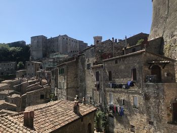 Buildings in city against clear blue sky