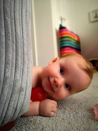 Portrait of cute girl lying on sofa at home