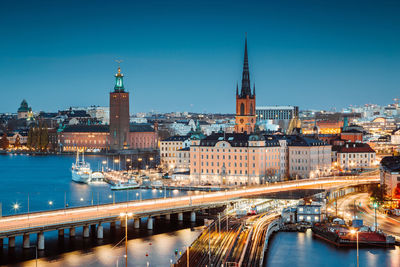 Illuminated cityscape against blue sky