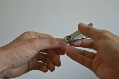 Close-up of man holding hands over white background