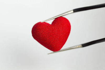 Close-up of red heart shape over white background