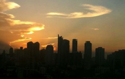 Skyscrapers in city at sunset