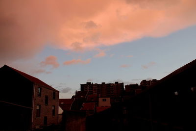 Low angle view of buildings against sky at sunset
