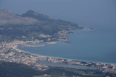 Aerial view of city and mountains against sky