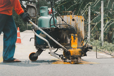 Road worker paint traffic lines on asphalt road surface.