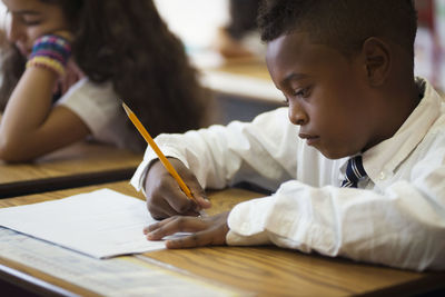 Boy sitting at desk during test in classroom