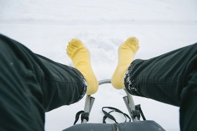 Low section of person sledding on snowfield