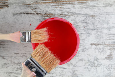 Close-up of hand holding red paint