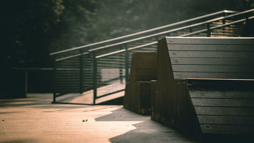 Empty bench on footpath by footbridge
