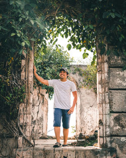 Full length portrait of young man standing against tree